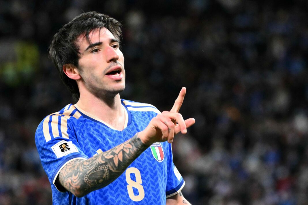 Los escudos de las selecciones de Italia y Bosnia y Herzegovina, separados por un balón de fútbol.